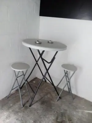 a small table with two stools next to a wall at Agréable maison avec cour à 10min de Liège in Herstal