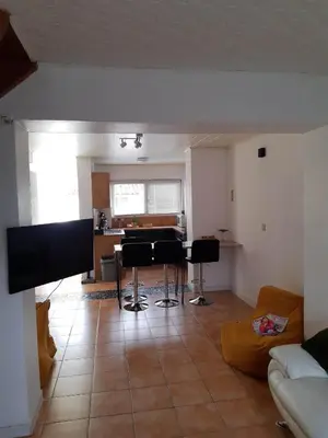 a living room with a table and chairs in it at Agréable maison avec cour à 10min de Liège in Herstal