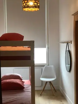a bedroom with a bunk bed with a mirror and a chair at Gîte Jaja in Limbourg