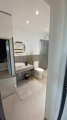 a white bathroom with a toilet and a sink at Le Makalle in Dalhem