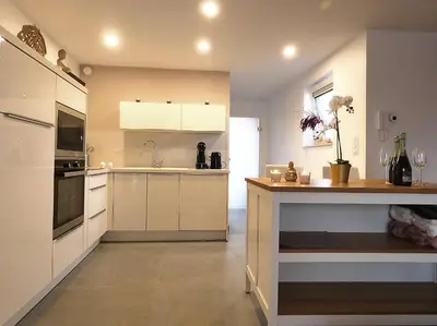 a large kitchen with white cabinets and a counter at SuiteDreams - Relax Suite Liège in Liège