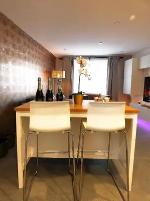 a kitchen with a counter with three bottles of wine at SuiteDreams - Relax Suite Liège in Liège