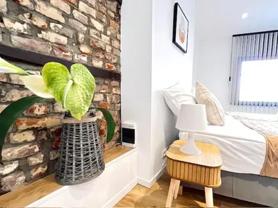 a bedroom with a plant in a vase next to a bed at Logies by Suzan in Hasselt