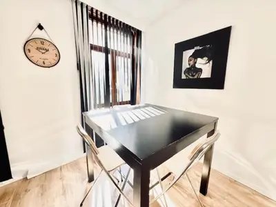 a black table and chairs in a room with a clock at Logies by Suzan in Hasselt