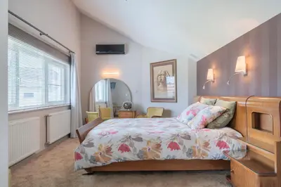 a bedroom with a bed and a large window at Ruime woning met grote omheinde tuin in Hasselt
