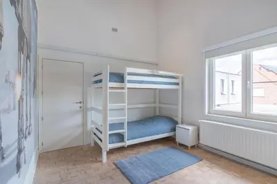 a bedroom with a bunk bed and a window at Ruime woning met grote omheinde tuin in Hasselt