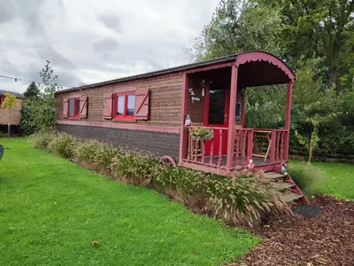 a small house with red trim in a yard at Margaux B&B Babbita in Stokrooie