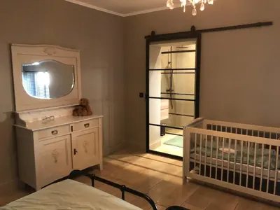 a baby room with a crib and a large window at de Kegelhoeve in Zonhoven