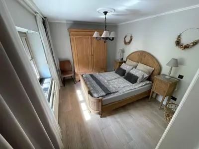 a bedroom with a bed and a wooden floor at de Kegelhoeve in Zonhoven