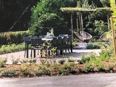 a dining table and chairs in a garden at de Kegelhoeve in Zonhoven