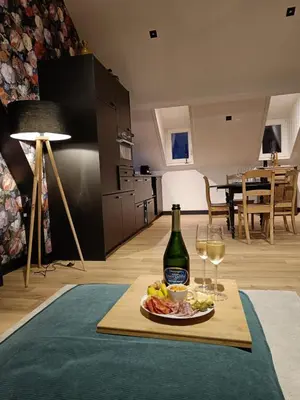 a table with a plate of food and a bottle of wine at Ô Colombages in Les Biolles