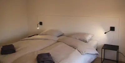 a white bed with four pillows in a room at Huize Clementina in Peer