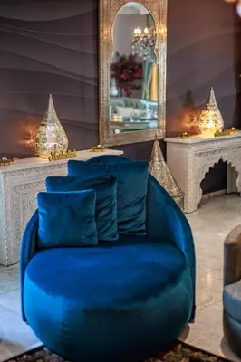 a blue couch in a room with a mirror at B&B 1001 nacht in Zonhoven