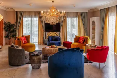 a living room with colorful furniture and a chandelier at B&B 1001 nacht in Zonhoven
