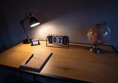 a desk with a clock and a book and a lamp at Vakantiewoning - ‘t Ouwershuys in Opoeteren