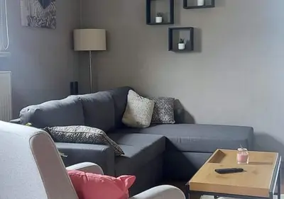 a living room with a blue couch and a table at Vakantiewoning - ‘t Ouwershuys in Opoeteren