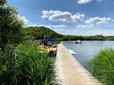 a dock on a lake with a boat in the water at BnB Pastel -B&B Breakfast Included- in Dilsen-Stokkem