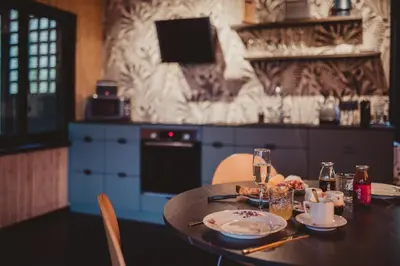 a kitchen with a table with plates and glasses on it at Ô NaNo Glamping in Dalhem