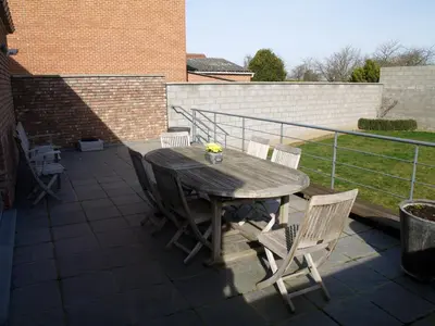 a wooden table and chairs on a patio at De Jölenberg in Heers