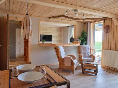 a living room with a table and chairs at La tanière in Chaudfontaine