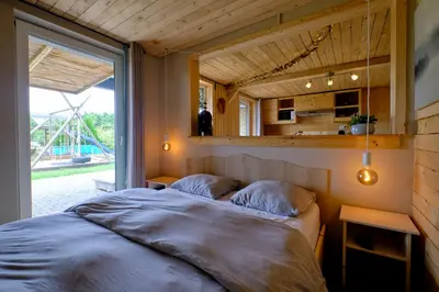 a bedroom with a bed and a large window at La tanière in Chaudfontaine