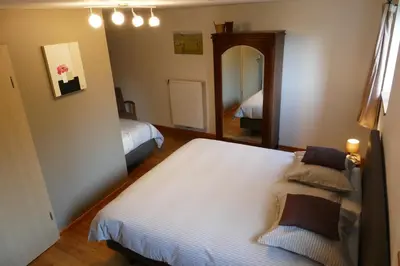 a bedroom with two beds and a mirror at B&B La ferme de Berwausault in Herve