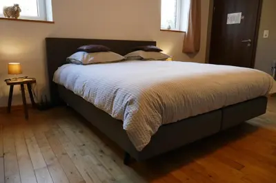 a bedroom with a large bed with white sheets and pillows at B&B La ferme de Berwausault in Herve