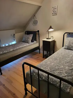 a bedroom with two beds and a table with a lamp at Welness gastenverblijf Carpe Diem in Oudsbergen