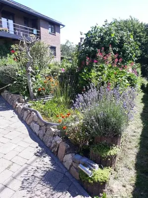 a garden with flowers and plants in front of a building at Studio Au jardin fleuri in Verviers