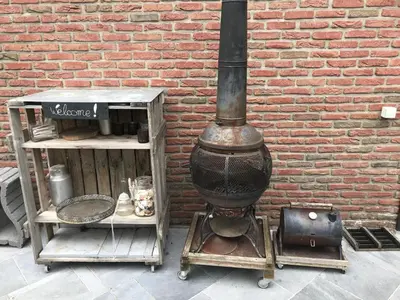 a brick wall with a wood stove next to a building at Studio Au jardin fleuri in Verviers