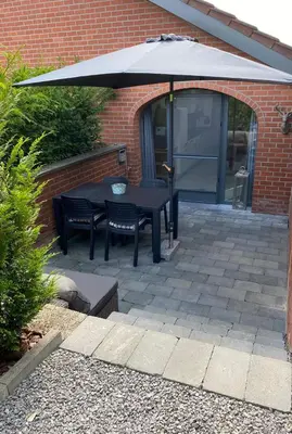a black table and chairs under an umbrella at bij Petros in Oudsbergen