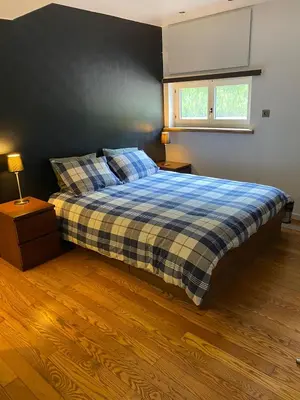 a bedroom with a bed with a plaid blanket and a window at bij Petros in Oudsbergen