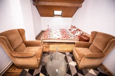 a living room with two chairs and a bed at Belle chambre sur liège in Liège
