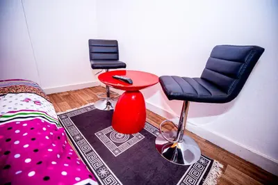 a room with two chairs and a table and a bed at Superbe chambre sur liège in Liège