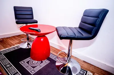 two chairs and a red stool next to a table at Superbe chambre sur liège in Liège
