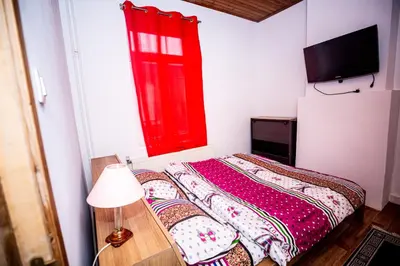 a bedroom with a red window and a bed with pillows at Superbe chambre sur liège in Liège
