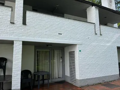 a white brick house with chairs and a patio at Hengelhoef Acacia 3 in Drijhoeven