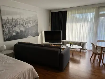 a bedroom with a couch and a tv and a table at Alexis's loft in Liège