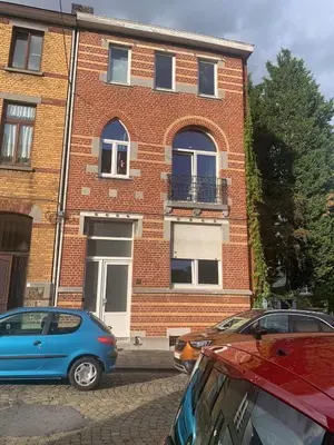 two cars parked in front of a brick building at Les chineurs du 81 in Liège
