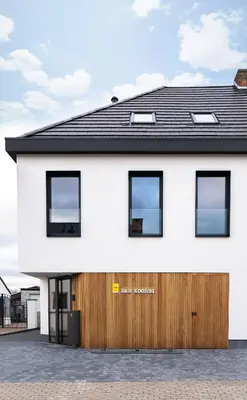 a white house with a black roof at B&B Koor91 in Hasselt