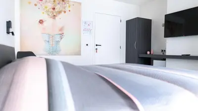 a bedroom with a bed and a painting of a man on the wall at B&B Koor91 in Hasselt