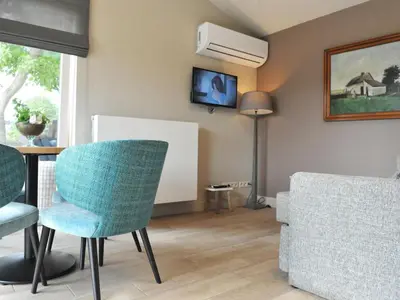 a living room with a table and chairs at Vlaanderen Cozy Cottage in Eisden