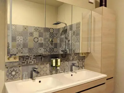 a bathroom with a sink and a mirror at Vlaanderen Cozy Cottage in Eisden