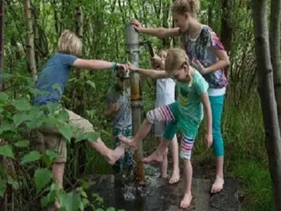 a group of children playing with a fire hydrant at Vlaanderen Cozy Cottage in Eisden