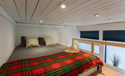 a bedroom with a bed with a plaid blanket at Le Studio Compostelle by Maison Brasseurs d'Etoiles - Appartement 2 personnes in Liège