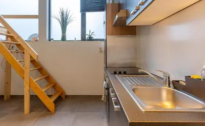 a kitchen with a sink and a staircase at Le Studio Compostelle by Maison Brasseurs d'Etoiles - Appartement 2 personnes in Liège