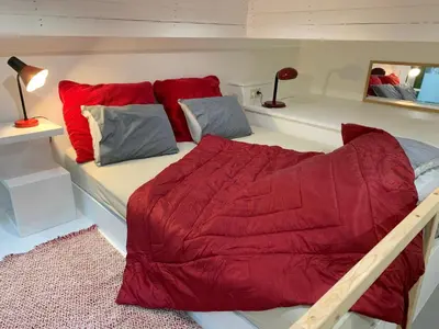 a bed with a red comforter in a room at Le Loft Nautilus by Maison Brasseurs d'Etoiles in Liège