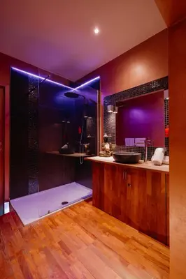 a bathroom with a sink and a shower with purple lighting at Ô Secret in Liège