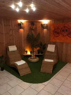 a room with wicker chairs and a table at JustB in Riemst