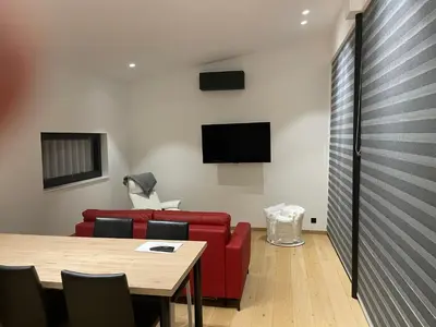 a living room with a red couch and a table at Tiny house moderne in Thimister